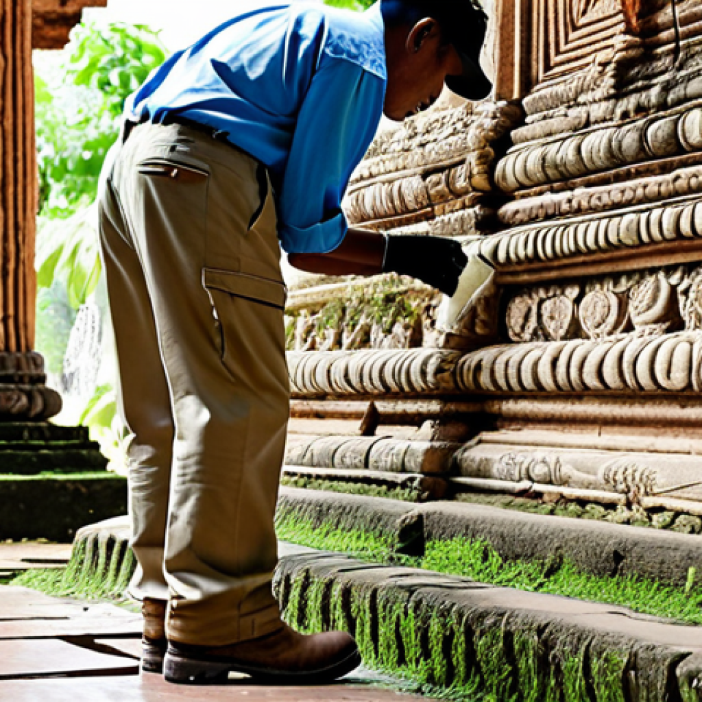 **
A professional conservationist, fully clothed in appropriate work attire (khaki pants, sturdy work boots, a light-colored button-down shirt), carefully cleaning a section of ornate stucco on an ancient temple wall in Ayutthaya, Thailand. The temple is partially ruined, with visible wear and tear. Sunlight streams through gaps in the structure, illuminating the work area. Safe for work, appropriate content, professional, modest, perfect anatomy, correct proportions, well-formed hands, natural pose, high quality.
**